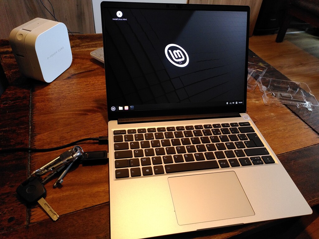 Le Framework ouvert et allumé, l'écran d'installation de Linux Mint est affiché.